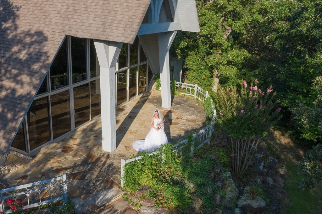Bride standing on balcony overlook at Camp Loughridge Tulsa 