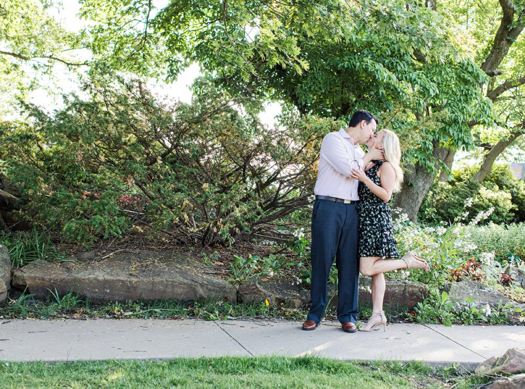 Girl pops foot while being kissed in front of tree in Gilcrease engagement