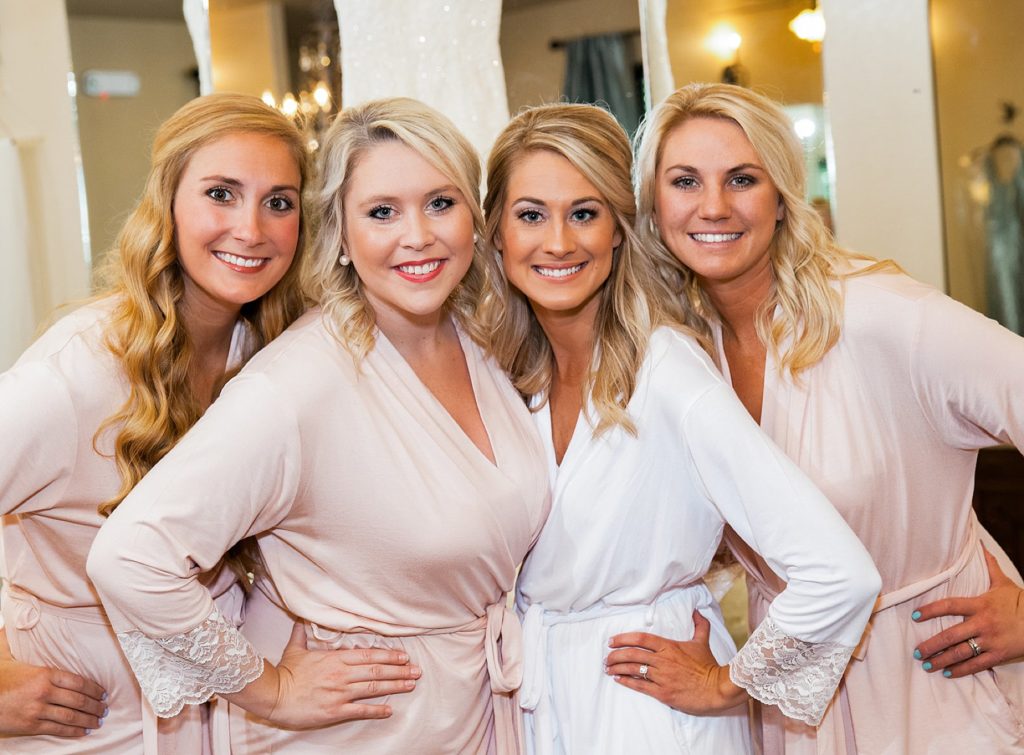 Bride and bridesmaids standing in pink lacy robes