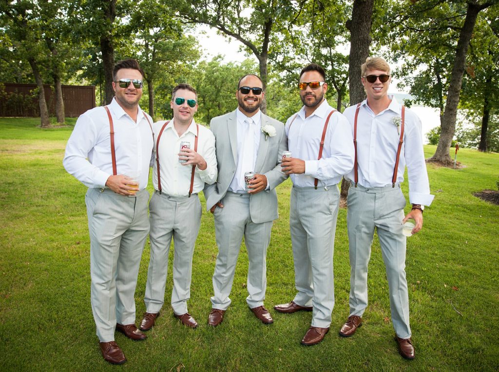 Groom and groomsmen in Grey and red suspender suit toasting at The Springs Wedding