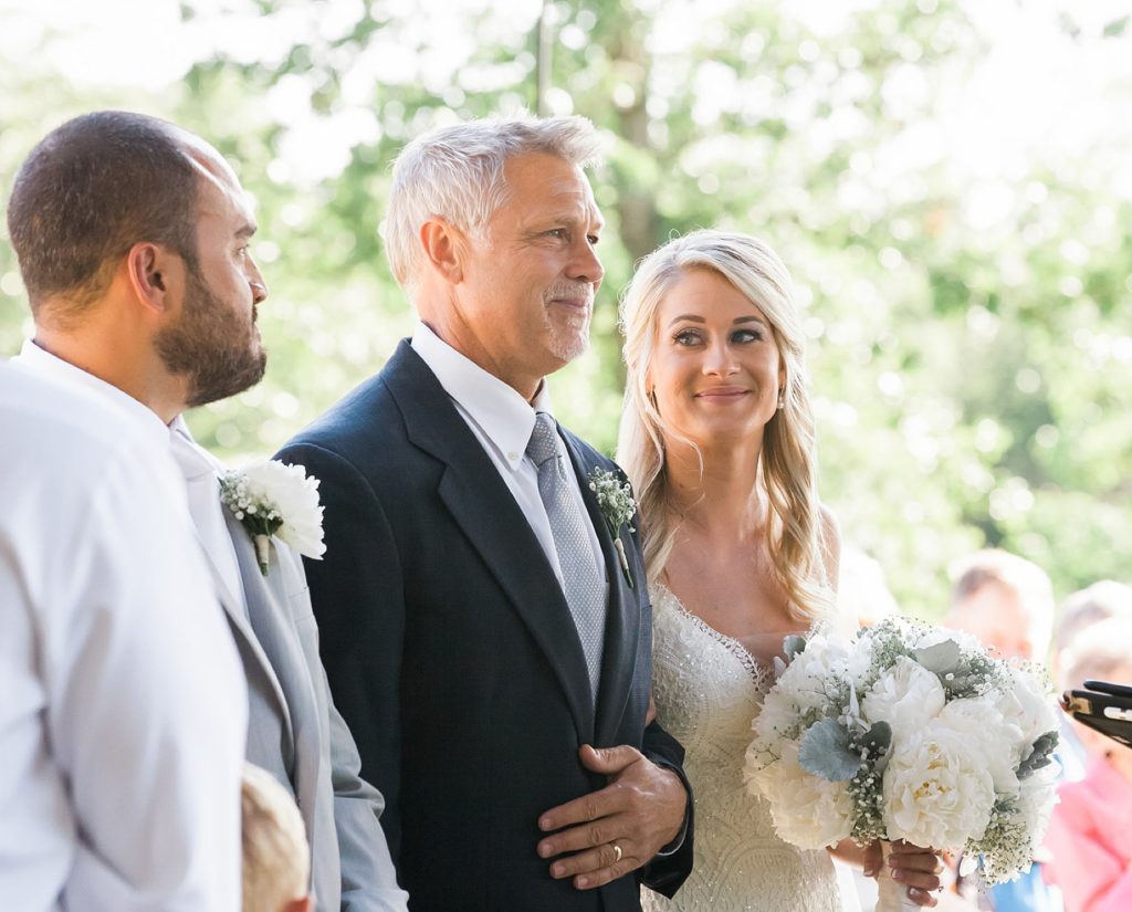 Father of the bride tearing up while giving daughter away at alter