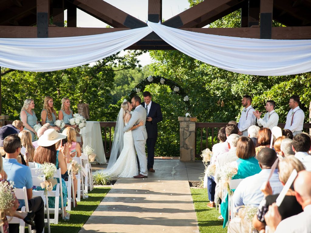 Bride and groom kiss at The Springs wedding alter