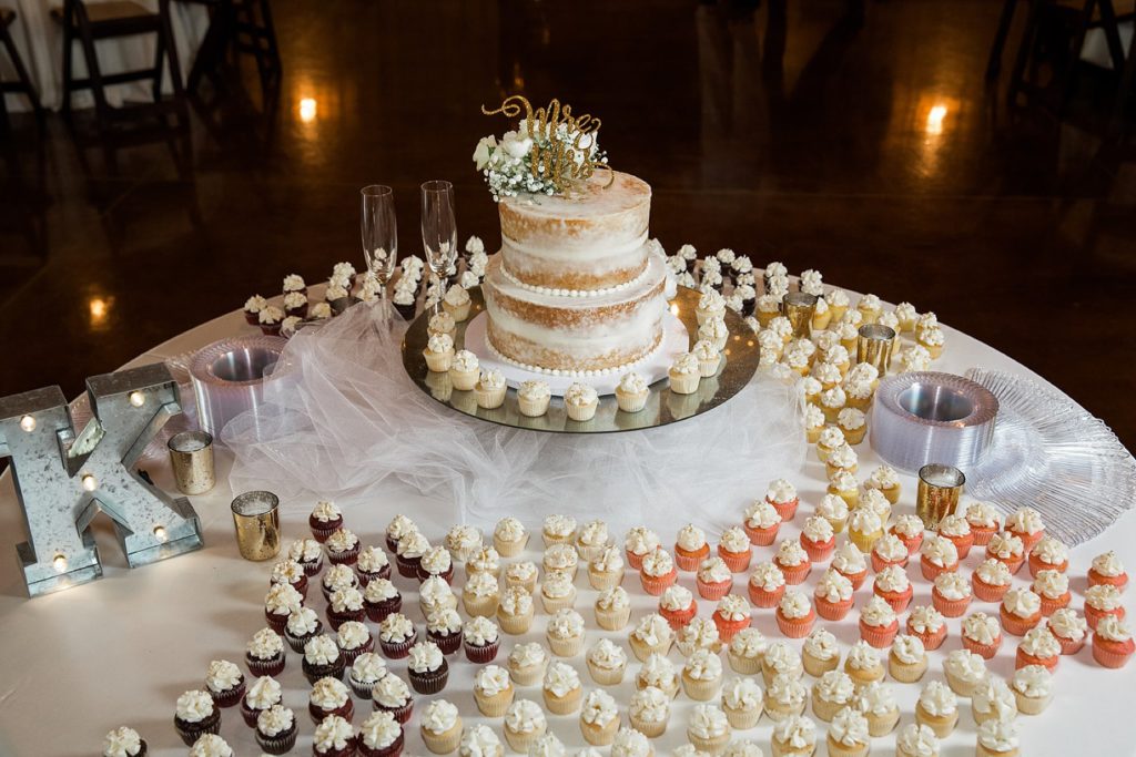 two tiered shaved wedding cake and tiny wedding cupcakes at The Springs event center