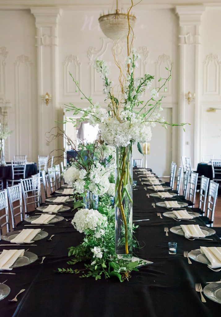 Black and white wedding table setup with greenery