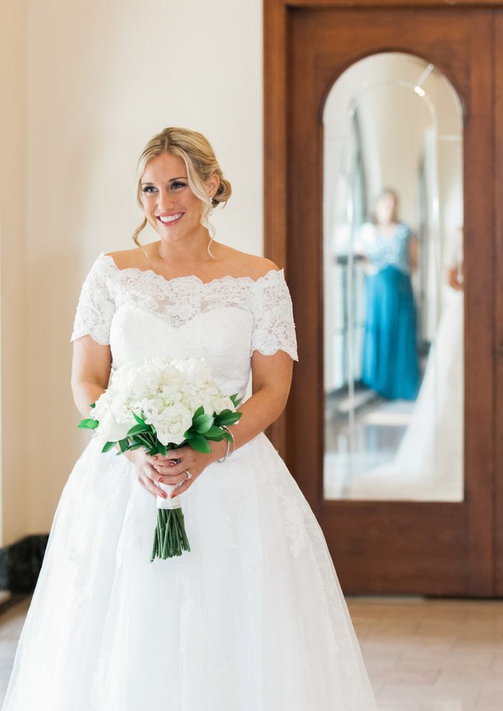 Bride standing holding white bridal bouquet