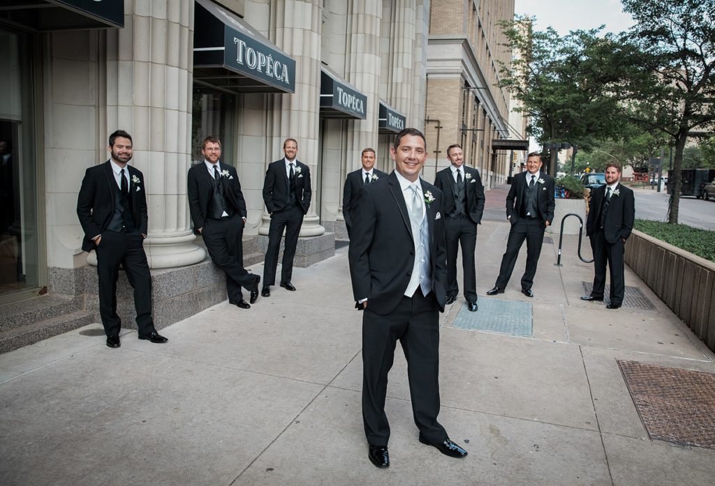 Groom and groomsmen standing outside the Mayo Hotel