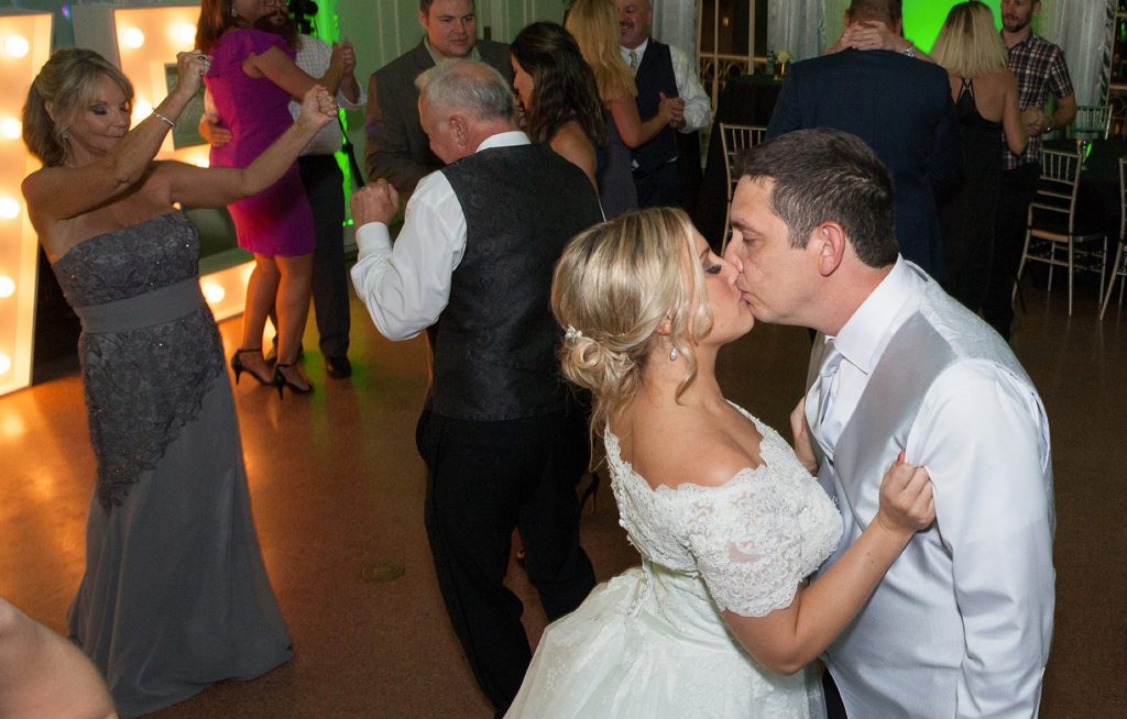 Bride and groom kiss on the dance floor