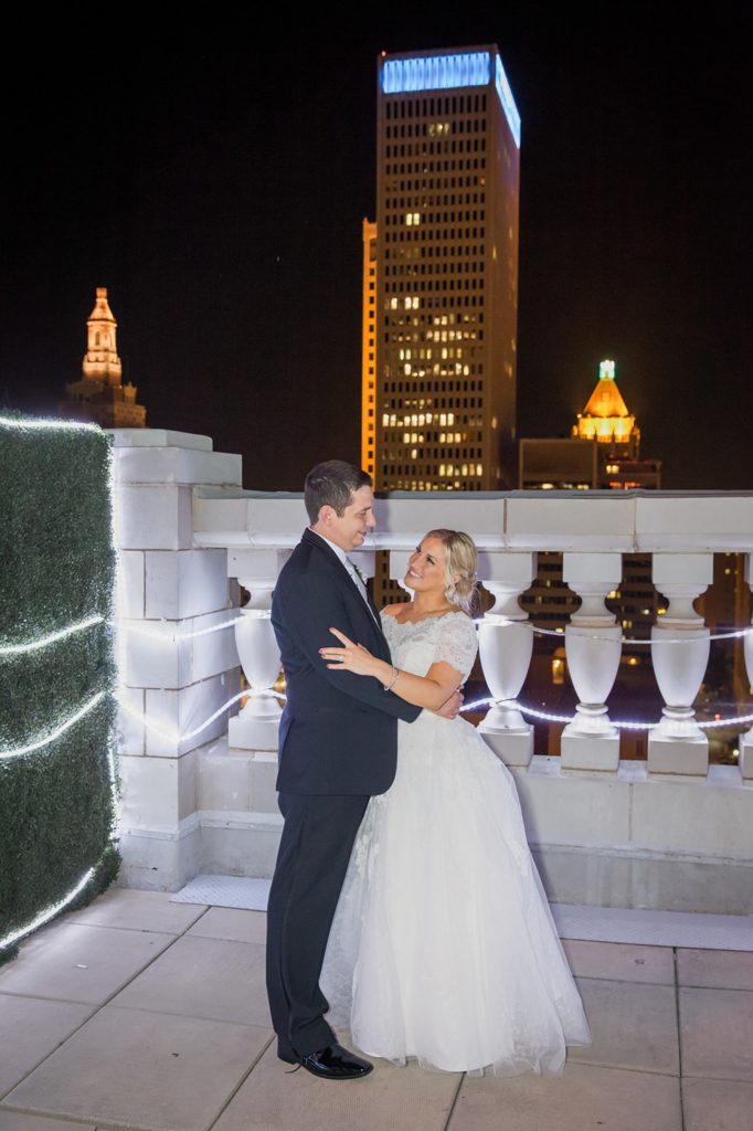 Bride and groom embracing on rooftop of The Mayo Hotel Tulsa
